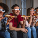 Personas viendo películas comiendo pizza
